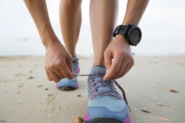 Young woman tying shoelace — Stock Photo, Image