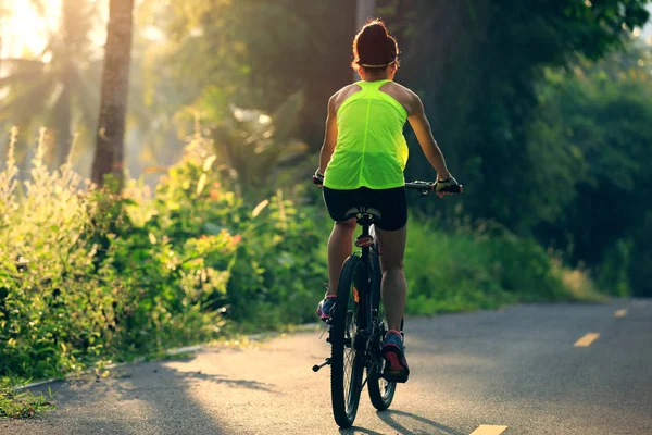 woman cycling on forest trail