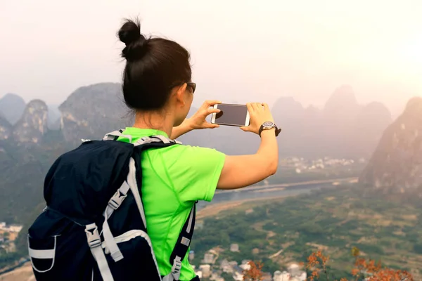 Backpacker biorąc obraz ze smartfonem — Zdjęcie stockowe