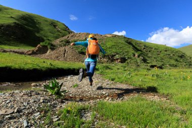 küçük nehir üzerinde atlama backpacking kadın