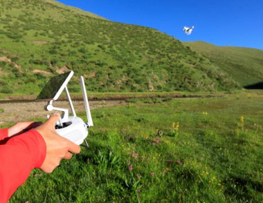 Gökyüzünde uçan dronun uzaktan kumanda kullanan kadın