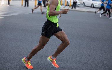 Şehir yolunda koşan maraton koşucusu bacakları