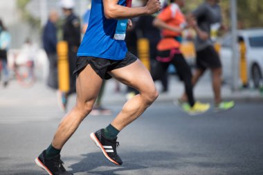 Şehir yolunda koşan maraton koşucusu bacakları