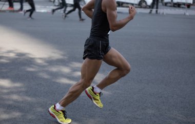 Şehir yolunda koşan maraton koşucusu bacakları