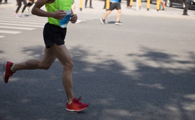 Şehir yolunda koşan maraton koşucusu bacakları