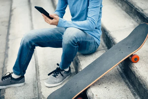 Met Behulp Van Smartphone Zittend Stad Trap Met Skateboard Skateboarder — Stockfoto