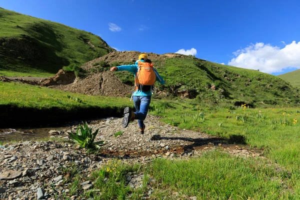 küçük nehir üzerinde atlama backpacking kadın