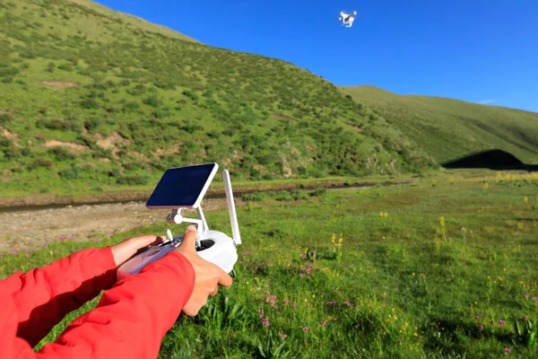 Gökyüzünde uçan dronun uzaktan kumanda kullanan kadın