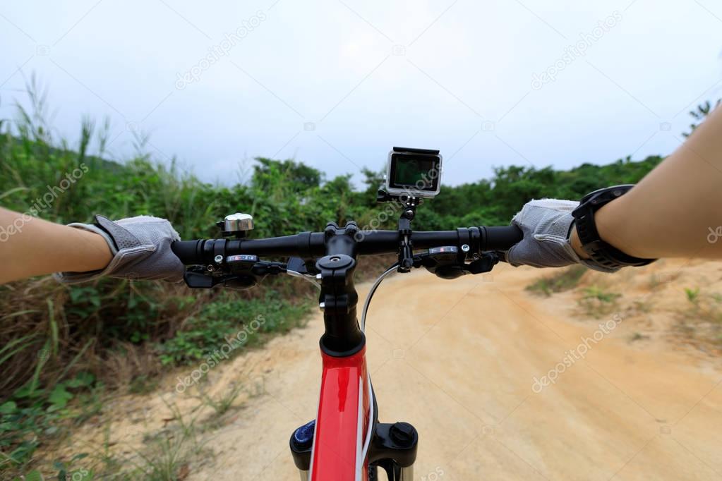 cyclist hands on handlebar of mountain bike on country road