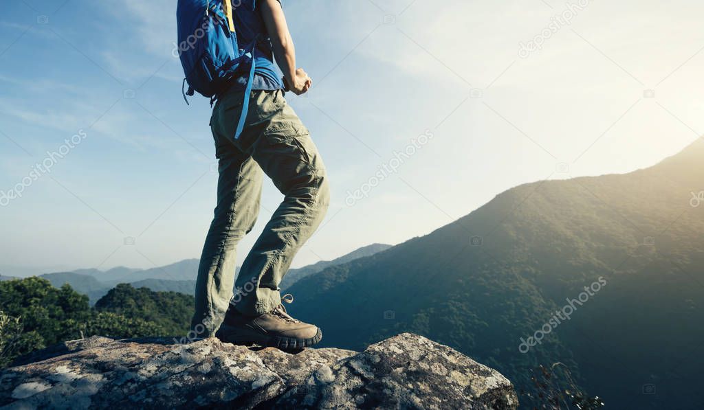 successful female backpacker enjoying the view from mountain top