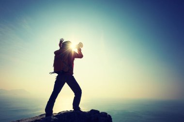 Rüzgarlı sahil uçurumunda hoparlörle bağıran genç bir kadın. 