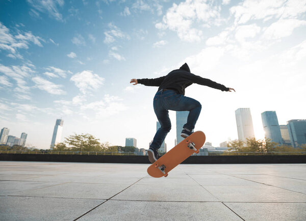 скейтбордистка прыгает по городу на скейтборде
