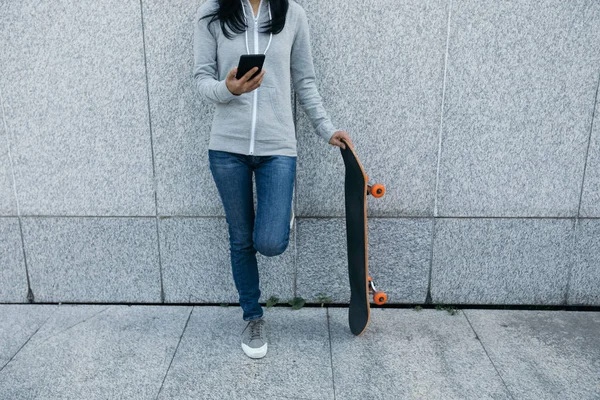Pomocí Smartphonu Opíraje Zeď Městě Ženské Skateboardista — Stock fotografie