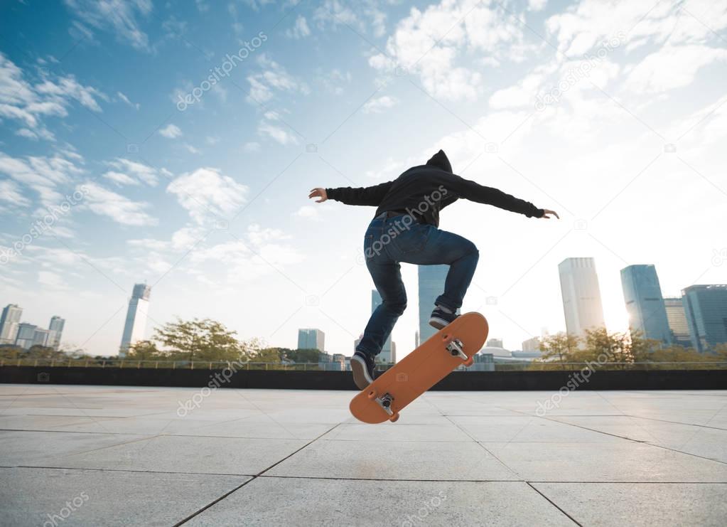 female skateboarder jumping on city with skateboard