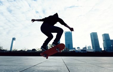 Skateboarder doing a trick named ollie in city park with skateboard clipart