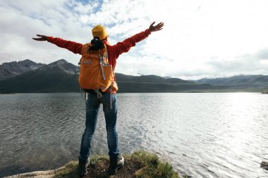 genç kadın Kollarını açarak yüksek rakım göl üzerinde backpacking