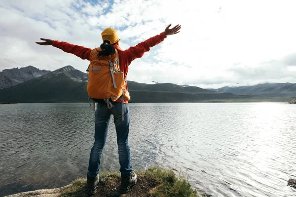 genç kadın Kollarını açarak yüksek rakım göl üzerinde backpacking