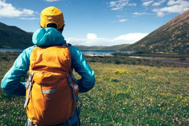 Genç backpacking kadın yüksek rakımlı dağlarda çayır üzerinde