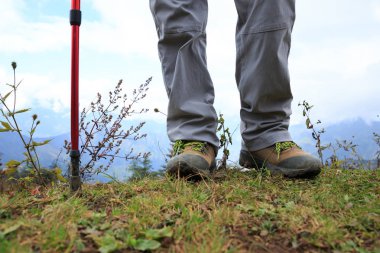 Dağın tepesinde duran başarılı kadın uzun yürüyüşe çıkan kimse bacaklar