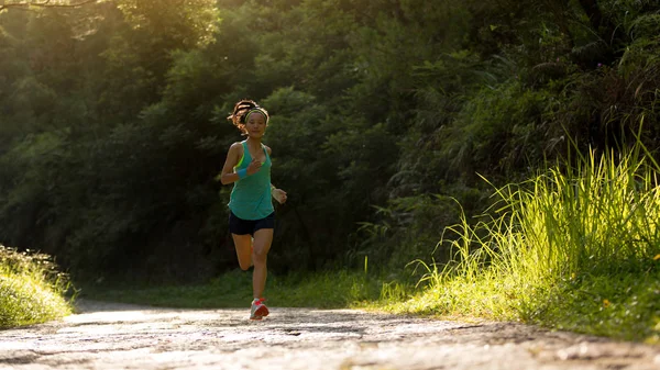 在森林小径上奔跑的年轻健身女子运动员 — 图库照片