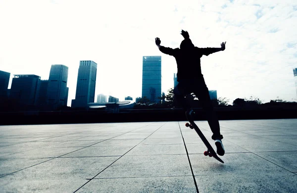 Skateboarder doing a trick named ollie in city park with skateboard