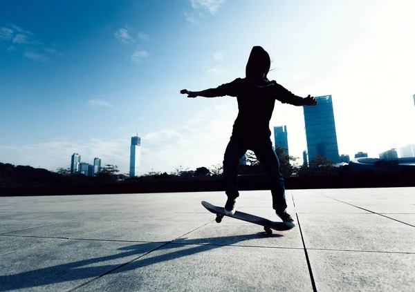 Skateboarder doing a trick named ollie in city park with skateboard