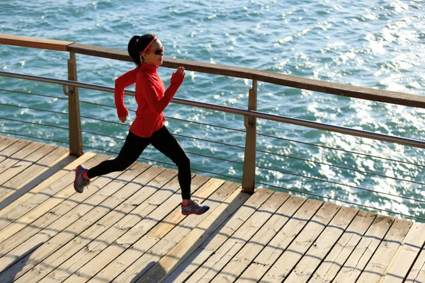 海辺の遊歩道の中にサンライズ スポーティな若い女性 — ストック写真