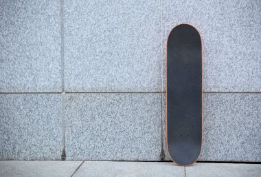 gri beton duvara bir kaykay