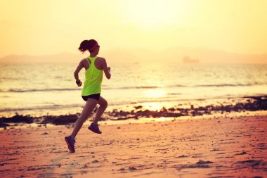 genç kadın kıyıda gündoğumu sırasında koşu