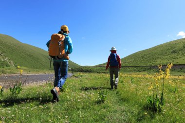 İki nehir kıyısındaki dağlardaki arkadaşlar backpacking