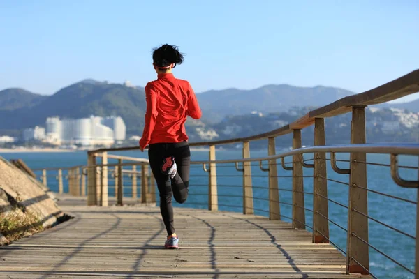 运动健身年轻女子在海滨木板路上奔跑 — 图库照片