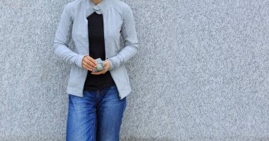 gri duvarının yakınında para sayma kadın