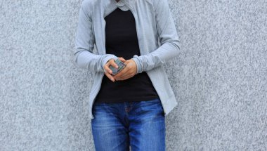 Gri duvara yakın duran ve şehir üzerinde para sayma kadın