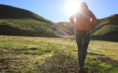bir sırt çantasıyla kadın gündoğumu dağlarda hiking