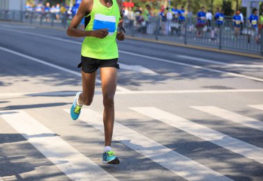 Şehir yolunda koşan maraton koşucusu bacakları