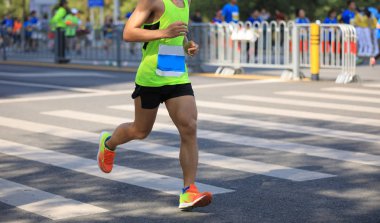 Şehir yolunda koşan maraton koşucusu bacakları