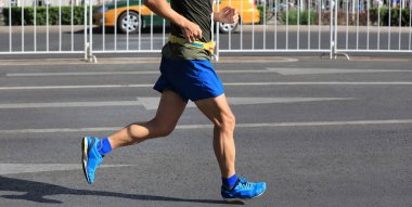 Şehir yolunda koşan maraton koşucusu bacakları