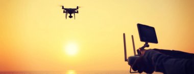 Uzaktan denetim uçmaktan tutan kadın hangi alarak fotoğraf gündoğumu deniz üzerine robot.