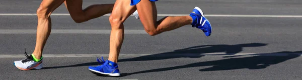 marathon runners legs running on city road