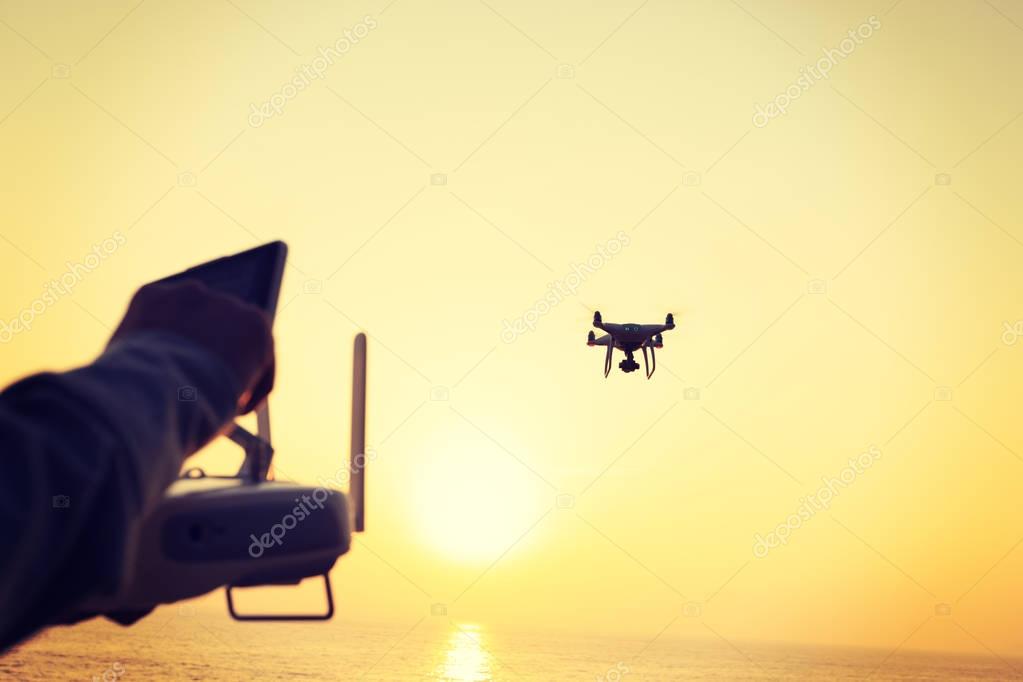 mujer sosteniendo el control remoto del dron volador que toma la foto