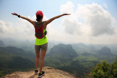 dağ üstte cliff kenarında duran uzanmış kollarıyla başarılı fiyatı 
