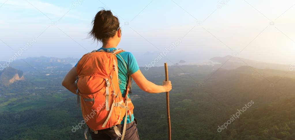 successful Hiker standing at cliff edge on mountain top