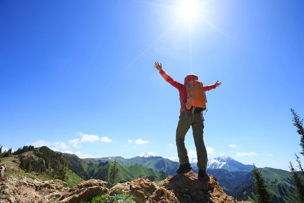 山の頂上の崖の端に立って両腕で成功したハイカー — ストック写真