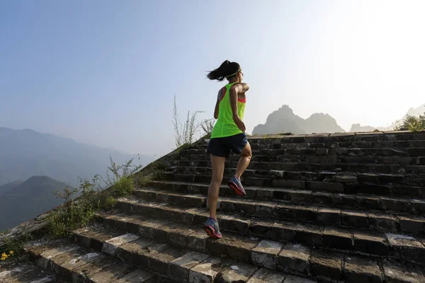 在山上的长城上奔跑的妇女足迹赛跑者 — 图库照片