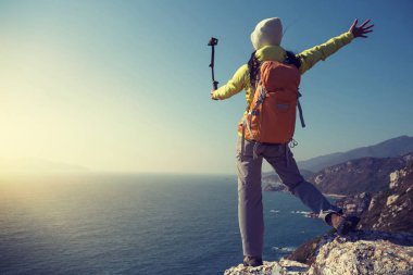 Genç kadın hiker eylem kamera ile deniz kenarında selfie alarak selfiestick monte