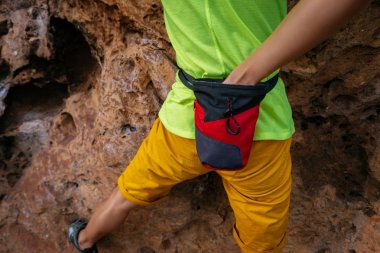 female rock climber climbing on steep cliff clipart