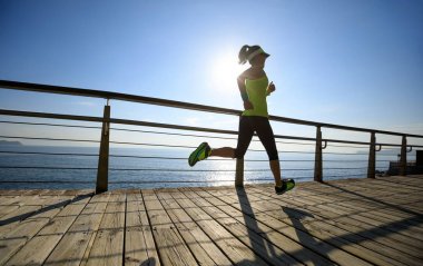 Sahil sahil üzerinde gündoğumu sırasında çalışan sportif fitness kadın 