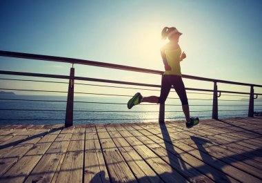 Sahil sahil üzerinde gündoğumu sırasında çalışan sportif fitness kadın 
