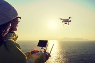 Uzaktan denetim uçmaktan tutan kadın hangi alarak fotoğraf gündoğumu deniz üzerine robot. 
