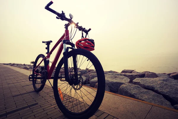 mountain bike with helmet on sunrise seaside